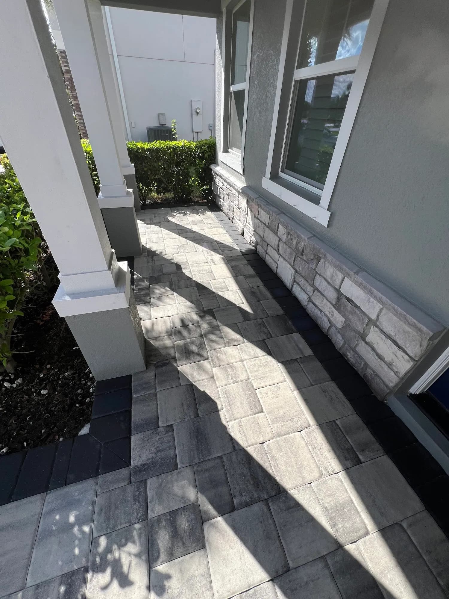 Paver side walkway beside a stone-veneer wall in Sarasota, FL